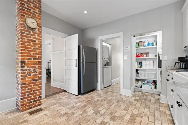 a kitchen with granite countertop a refrigerator stove and cabinets