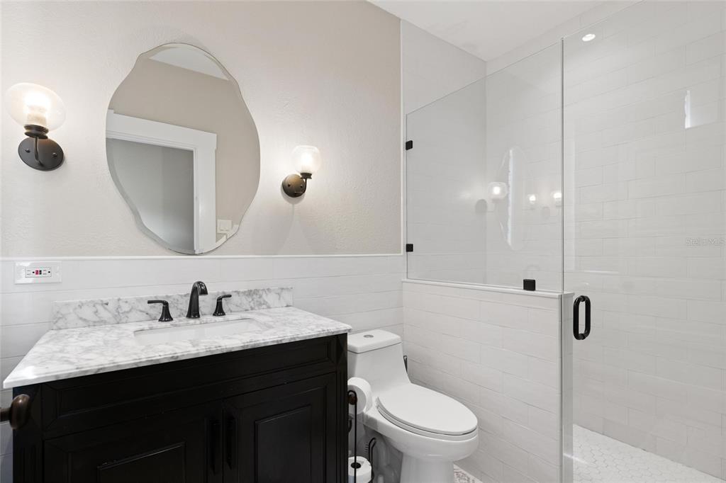 4 West Orange Street Tarpon Springs, FL 34689 - Photo 18 of 39 a bathroom with a sink a toilet a mirror and shower