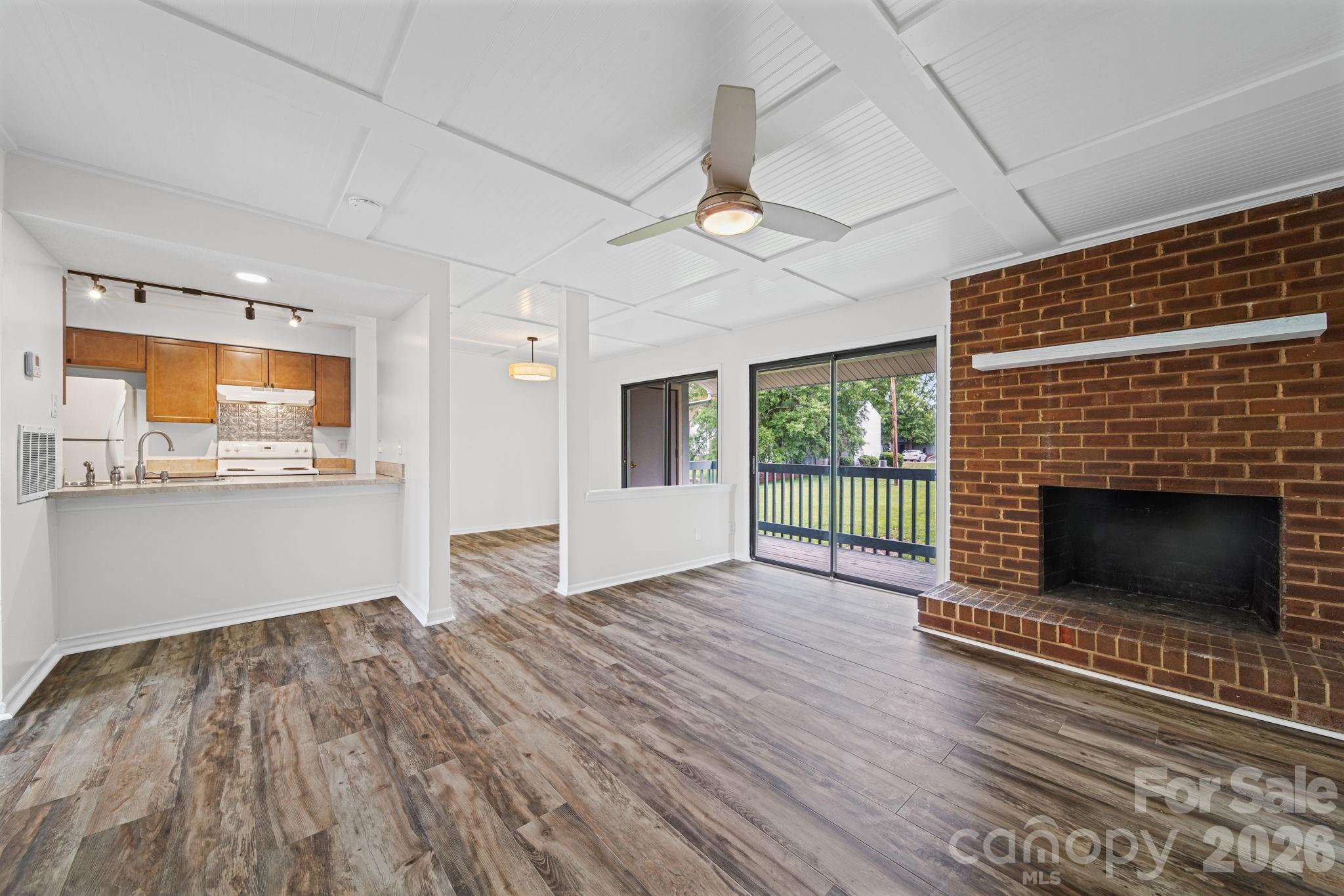 11023 Harrowfield Road Charlotte, NC 28226 - Photo 1 of 32 a view of empty room with wooden floor and fireplace