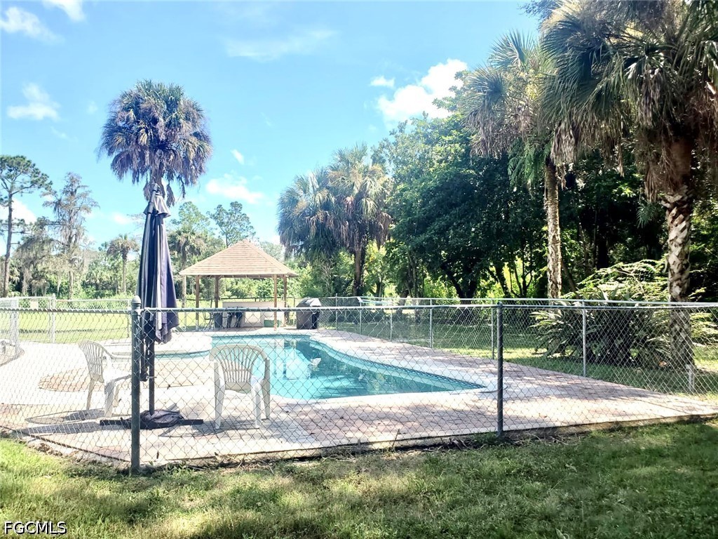 740 19th Street Southwest Naples, FL 34117 - Photo 25 of 35 a swimming pool with lots of tress in the background