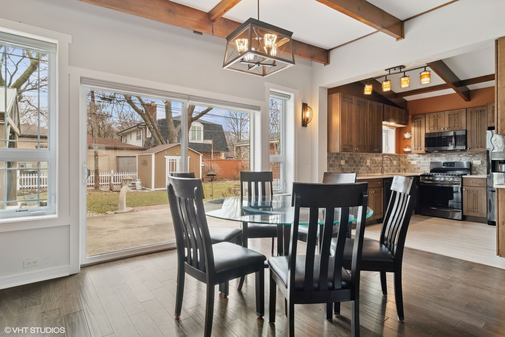 1505 Good Avenue Park Ridge, IL 60068 - Photo 4 of 19 a dining room with wooden floor a chandelier a glass table and chairs