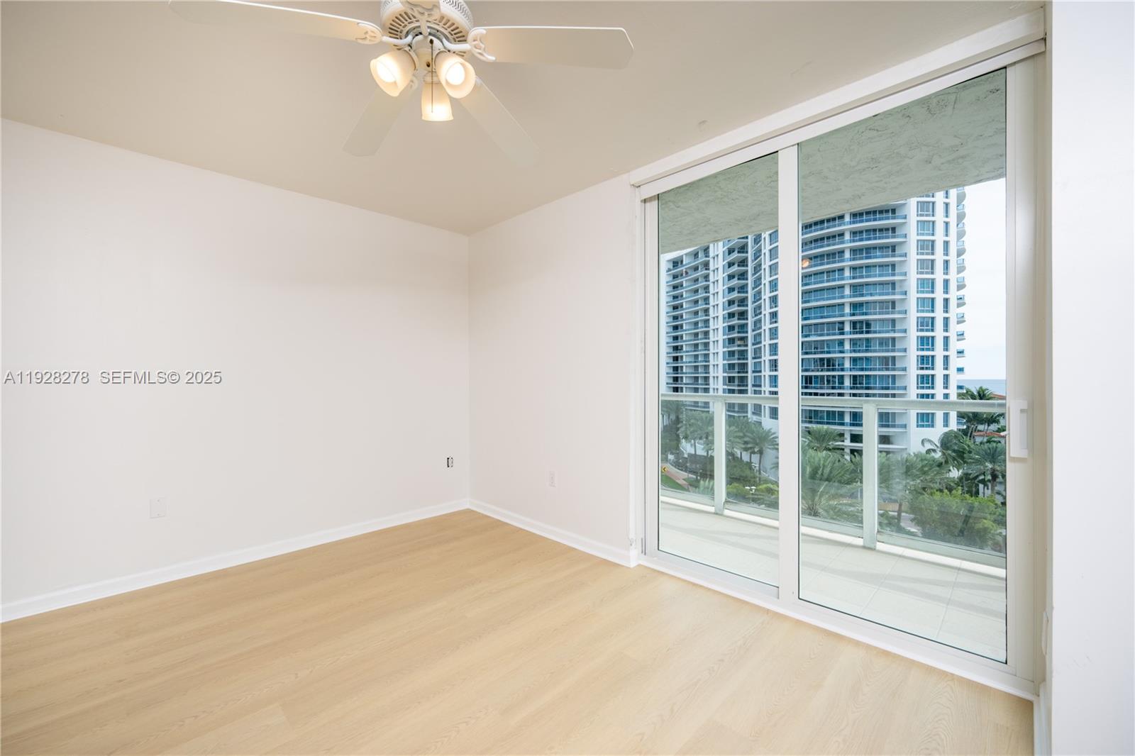 5900 Collins Avenue, Unit 906 Miami Beach, FL 33140 - Photo 20 of 49 a view of empty room with wooden floor and fan