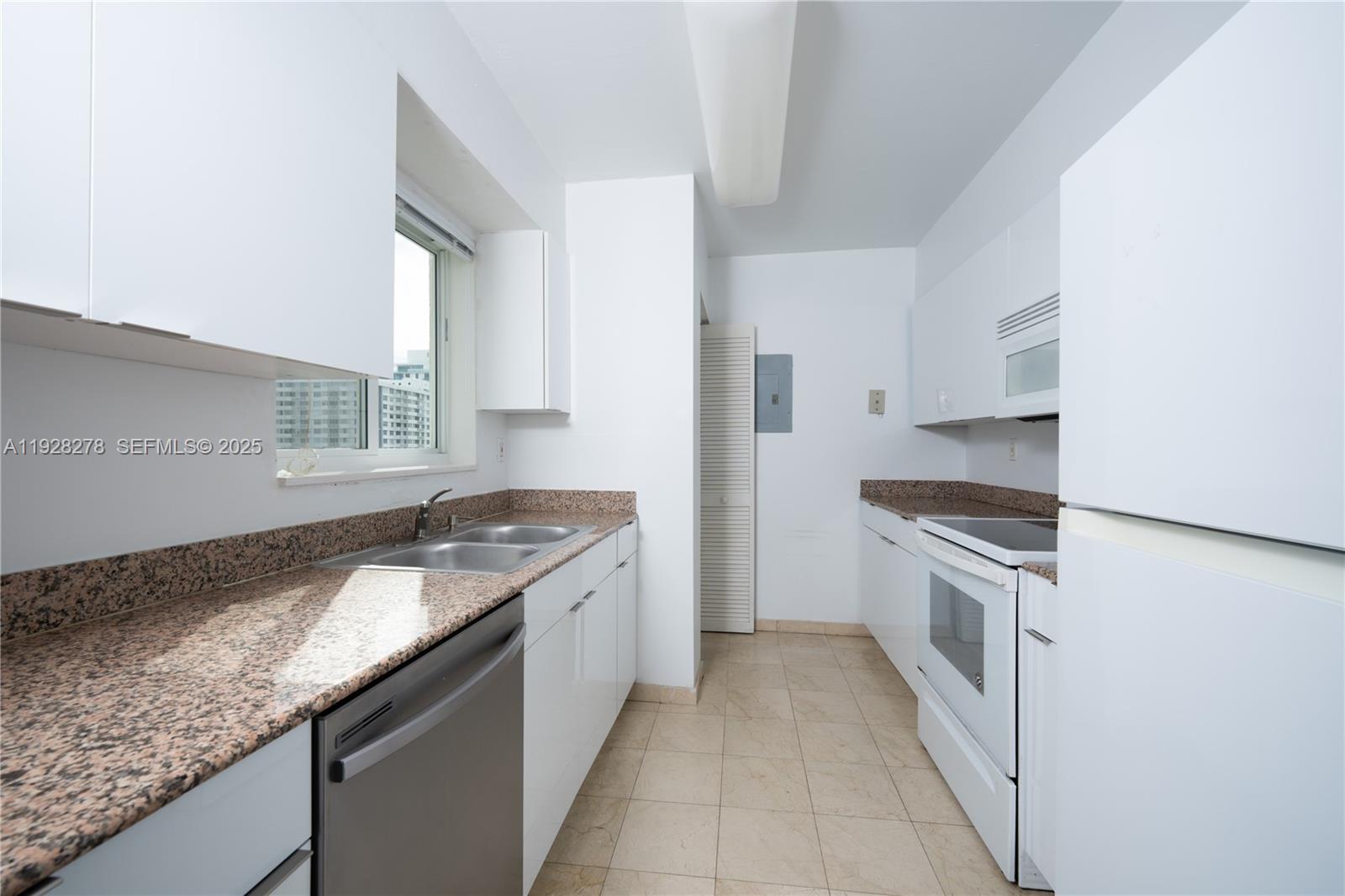 5900 Collins Avenue, Unit 906 Miami Beach, FL 33140 - Photo 9 of 49 a kitchen with granite countertop a sink stove and cabinets