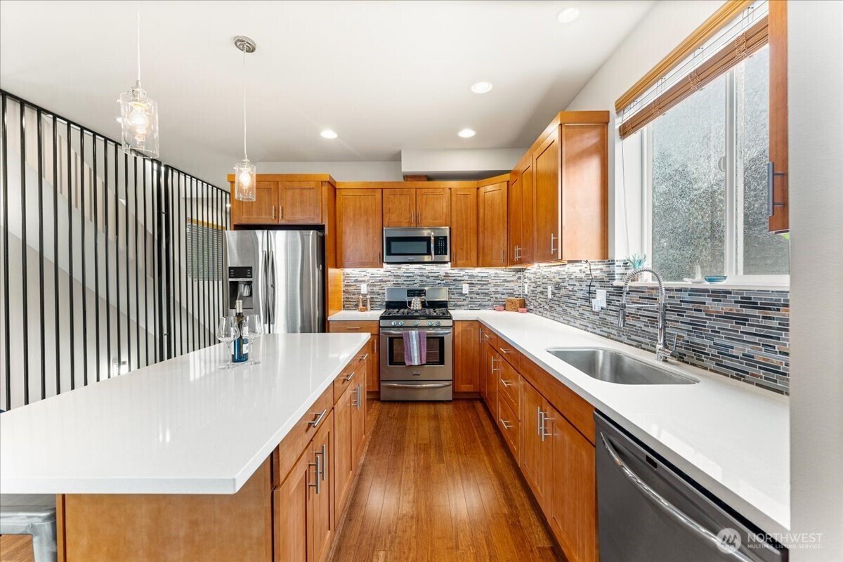 12418 2nd Place Southwest Burien, WA 98146 - Photo 8 of 39 a kitchen with stainless steel appliances granite countertop a sink a stove and a refrigerator