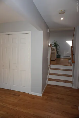 a view of a hallway with stairs and wooden floor