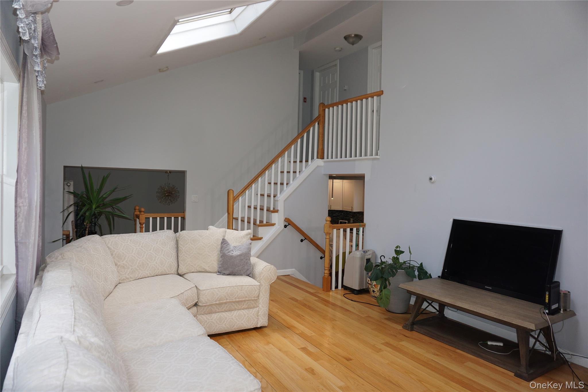 15 Greenridge Way Spring Valley, NY 10977 - Photo 10 of 17 Living area featuring wood finished floors, a skylight, stairs, and high vaulted ceiling