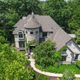a aerial view of a house with yard and trees in the background