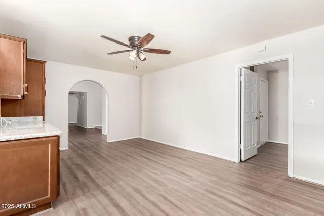 a view of a livingroom with wooden floor and a ceiling fan