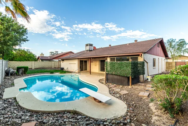 a view of a house with swimming pool and sitting area