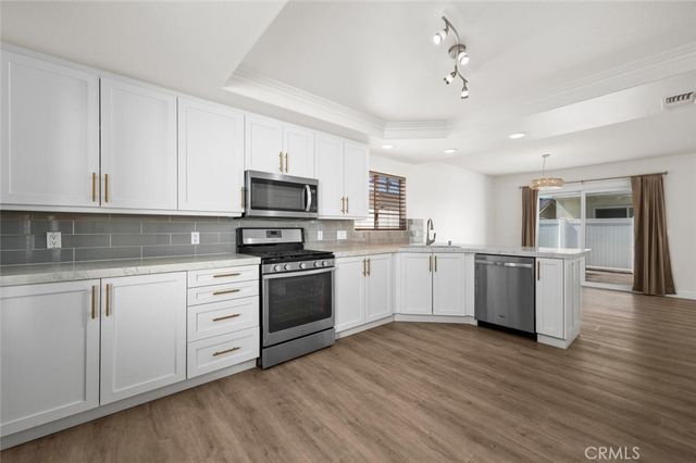 a kitchen with granite countertop white cabinets and white appliances