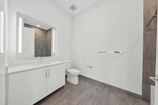 a bathroom with a toilet sink and mirror