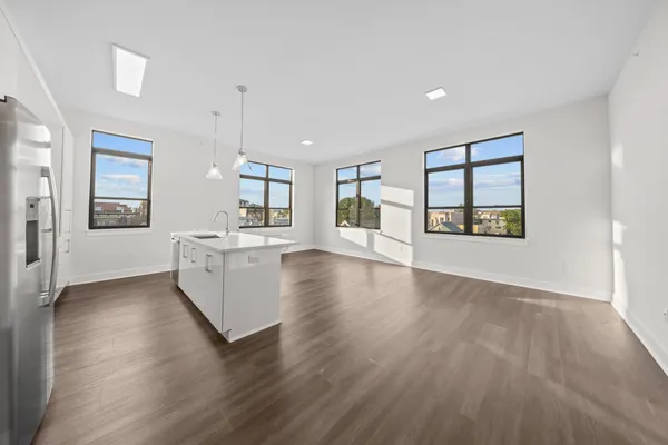 a view of a kitchen with wooden floor and a window