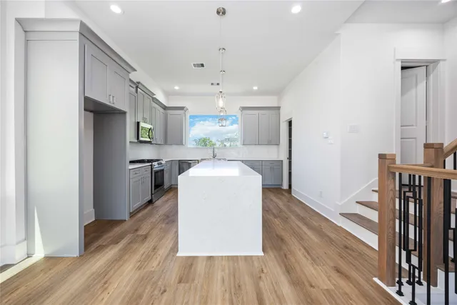 a kitchen with a refrigerator and a wooden floor