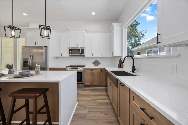 a kitchen with a sink a counter top space stainless steel appliances and a window
