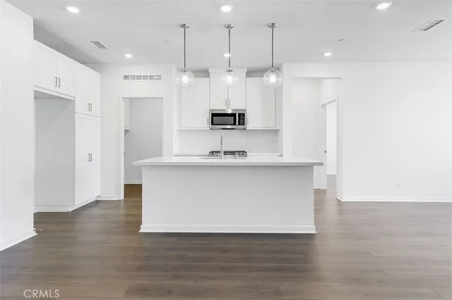 a view of kitchen with granite countertop cabinets and wooden floor