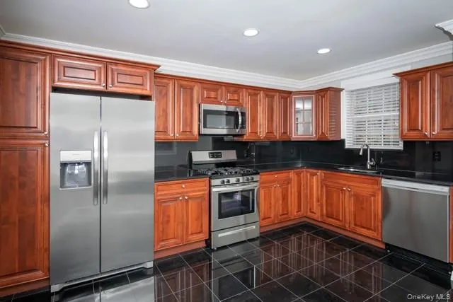 a kitchen with stainless steel appliances granite countertop a refrigerator a sink a stove a microwave and island