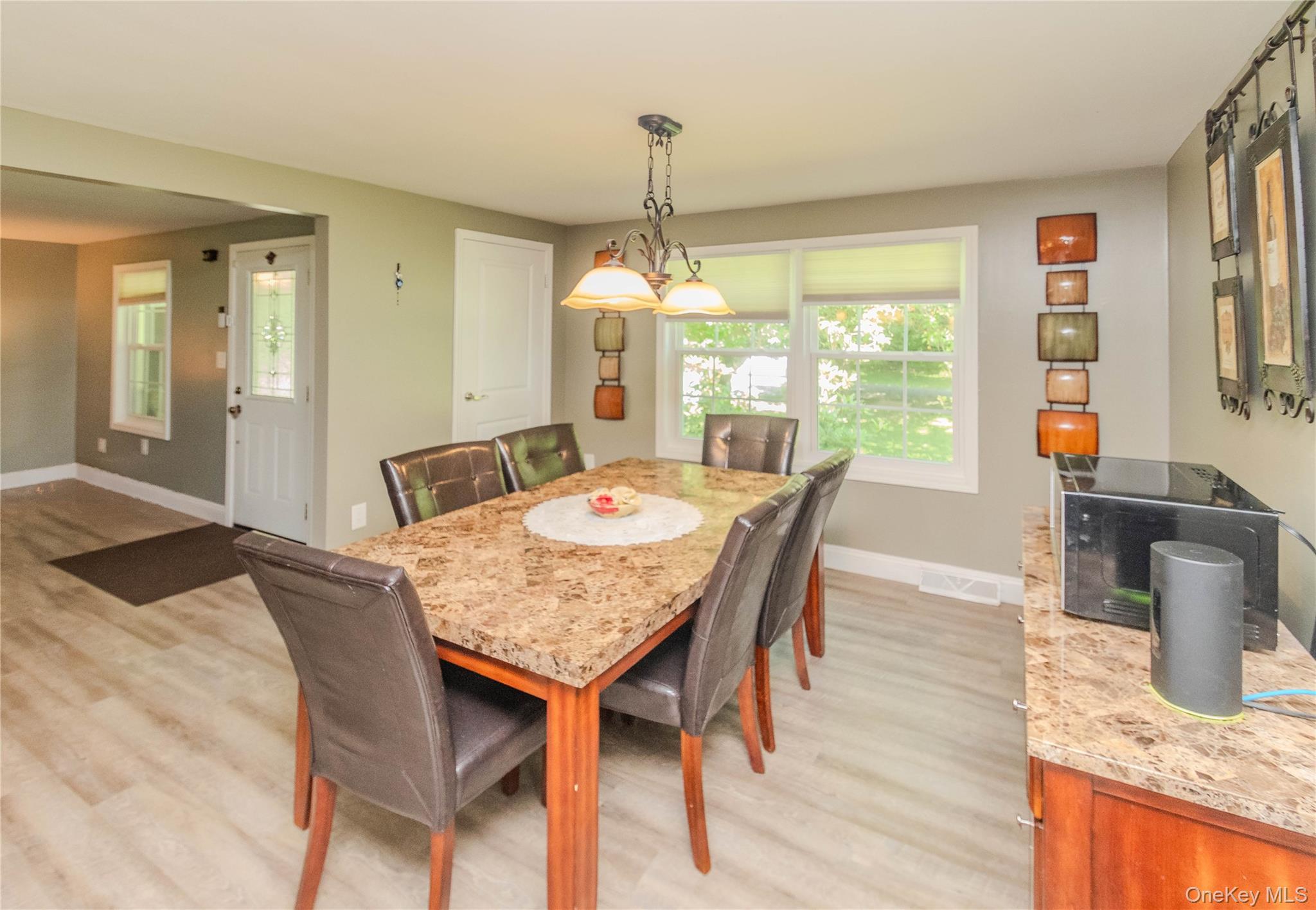 15 Van Dewark Road Middletown, NY 10941 - Photo 12 of 41 Dining area featuring wood-finish flooring, a contemporary chandelier, and a built-in buffet with a stone-finish countertop