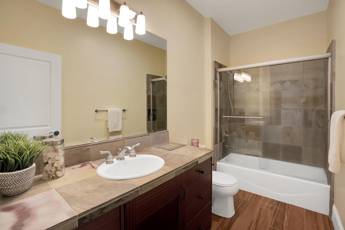 3030 Pleasant Valley Road Aptos, CA 95003 - Photo 41 of 70 a bathroom with a granite countertop sink a toilet a mirror and shower