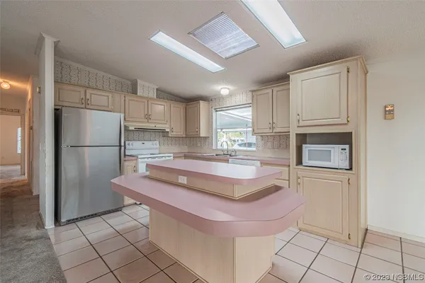 a kitchen with stainless steel appliances granite countertop a refrigerator and a stove top oven