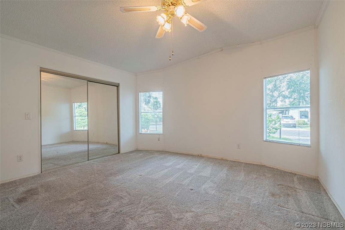 333 Schooner Avenue Edgewater, FL 32141 - Photo 16 of 31 an empty room with chandelier fan and windows