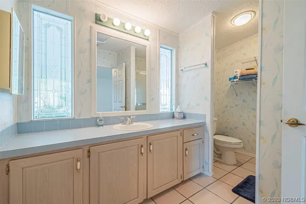 a bathroom with a granite countertop sink a toilet and a mirror