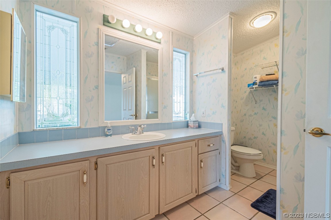 333 Schooner Avenue Edgewater, FL 32141 - Photo 17 of 31 a bathroom with a granite countertop sink a toilet and a mirror