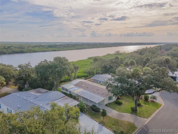 a view of a lake with a yard and large trees