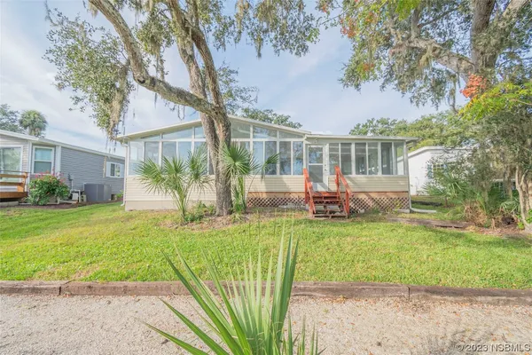 a view of a house with backyard and sitting area