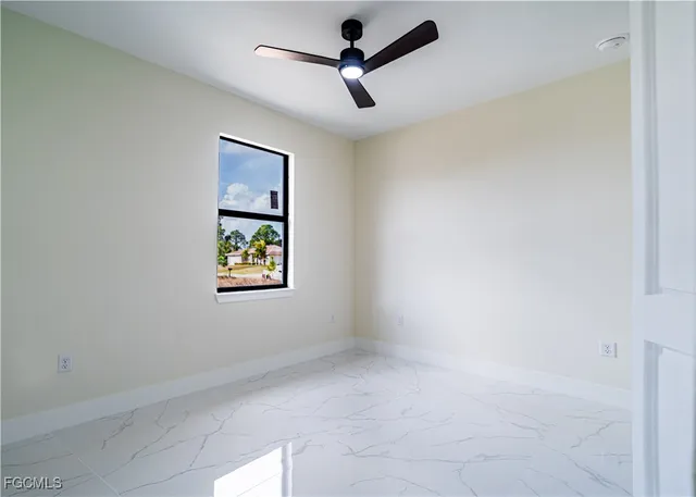 an empty room with a window and a fan