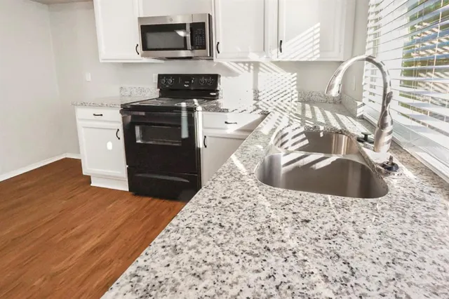 a kitchen with a sink stove and microwave
