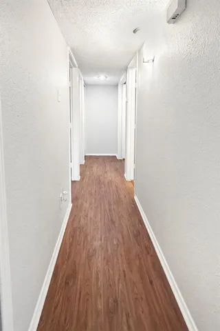 a view of a hallway with wooden floor