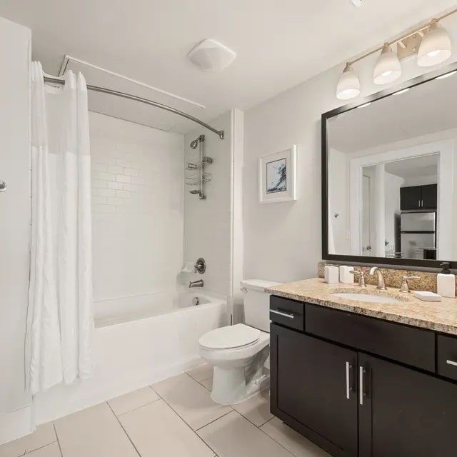 7200 Easy Wind Drive, Unit 2311 Austin, TX 78752 - Photo 13 of 20 a bathroom with a double vanity sink toilet mirror and shower