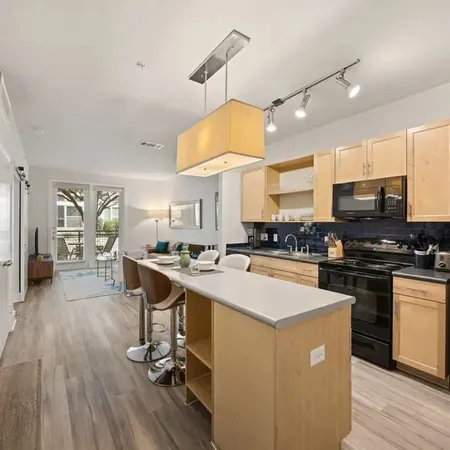 a kitchen with a sink a counter space appliances and cabinets