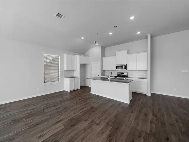 a view of kitchen with wooden floor and electronic appliances