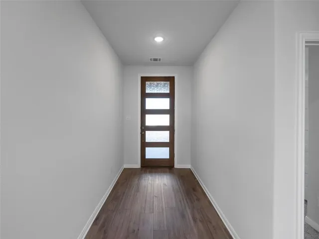an empty room with wooden floor and window