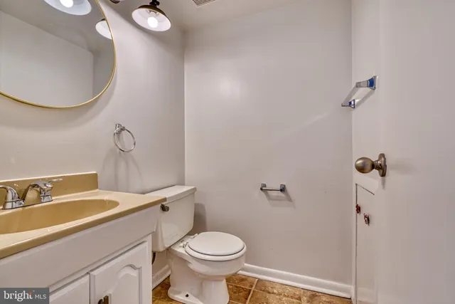 a bathroom with a sink mirror vanity and toilet