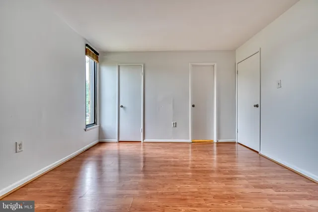 a view of an empty room with wooden floor