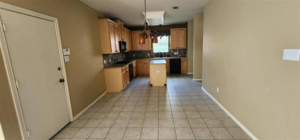 4204 Talbot Lane McKinney, TX 75070 - Photo 2 of 13 a kitchen with granite countertop a refrigerator and a stove top oven