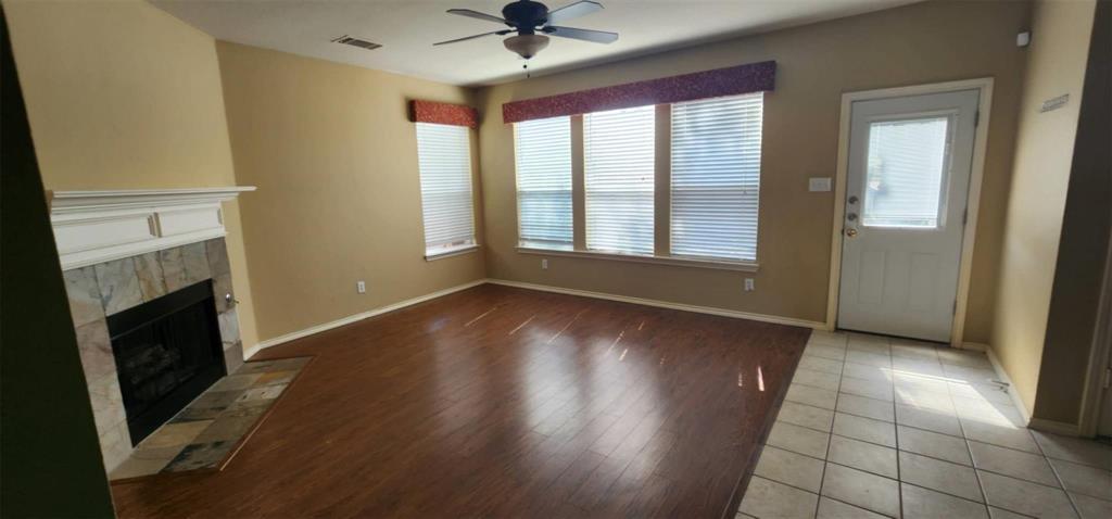 4204 Talbot Lane McKinney, TX 75070 - Photo 3 of 13 an empty room with wooden floor fireplace and windows