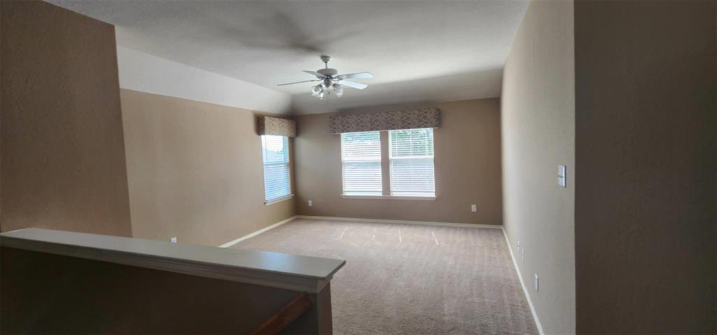 4204 Talbot Lane McKinney, TX 75070 - Photo 10 of 13 en empty room with windows and ceiling fan