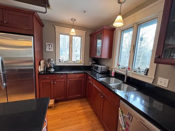a large kitchen with kitchen island granite countertop a large window and stainless steel appliances