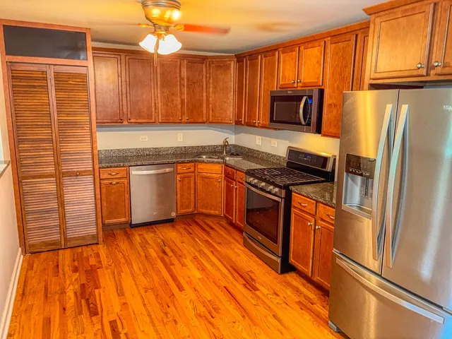 a kitchen with granite countertop stainless steel appliances and wooden cabinets