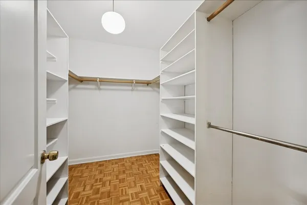 a view of walk in closet with empty racks