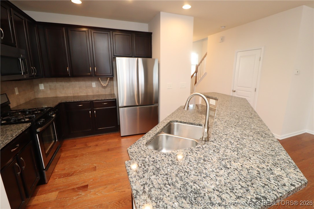 1712 Grace Point Road Morrisville, NC 27560 - Photo 12 of 35 a kitchen with kitchen island granite countertop a sink stove and refrigerator