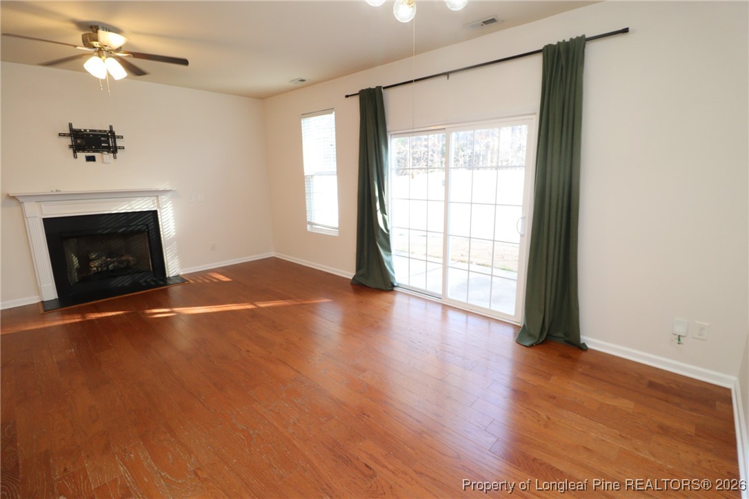 1712 Grace Point Road Morrisville, NC 27560 - Photo 21 of 35 an empty room with wooden floor fireplace and windows