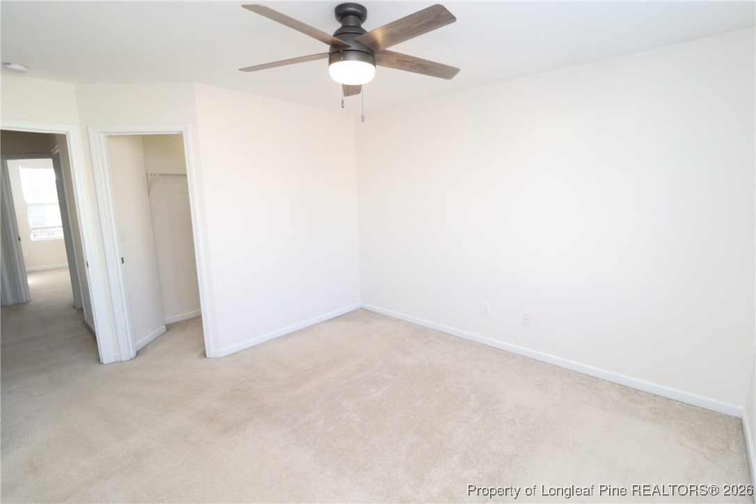 1712 Grace Point Road Morrisville, NC 27560 - Photo 25 of 35 an empty room with a ceiling fan and carpet