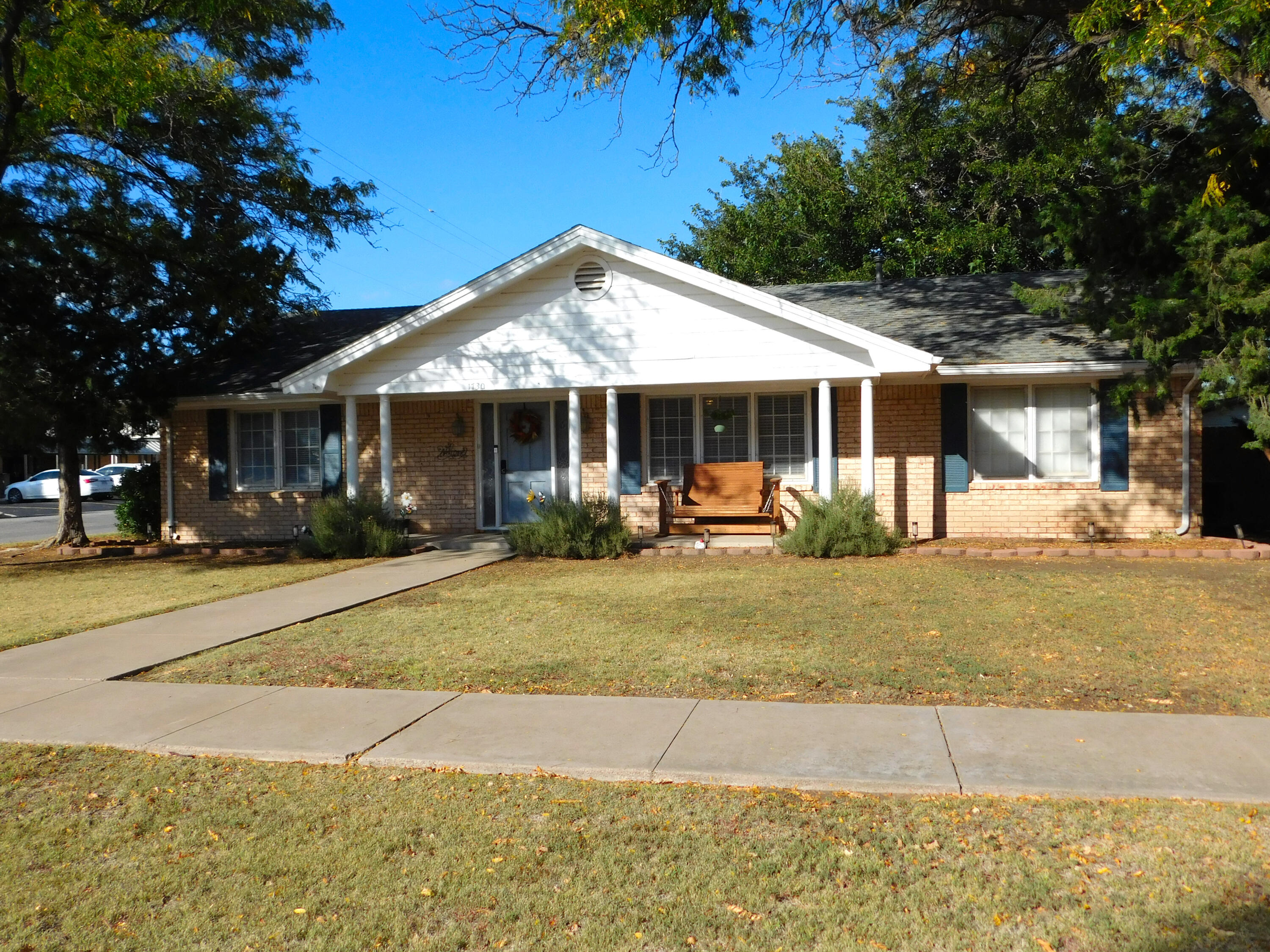 1730 West Ave F Muleshoe, TX 79347 - Photo 2 of 32 a front view of a house with a porch and a yard