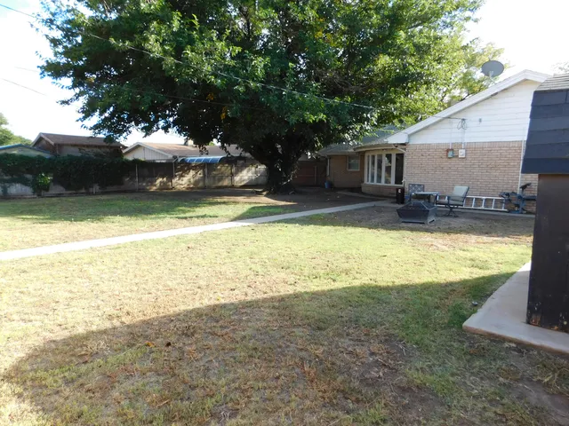 a view of a house with a yard and sitting area