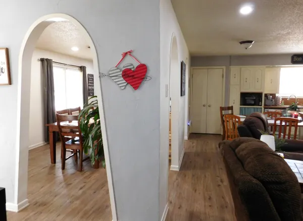a living room with furniture a dining table and wooden floor