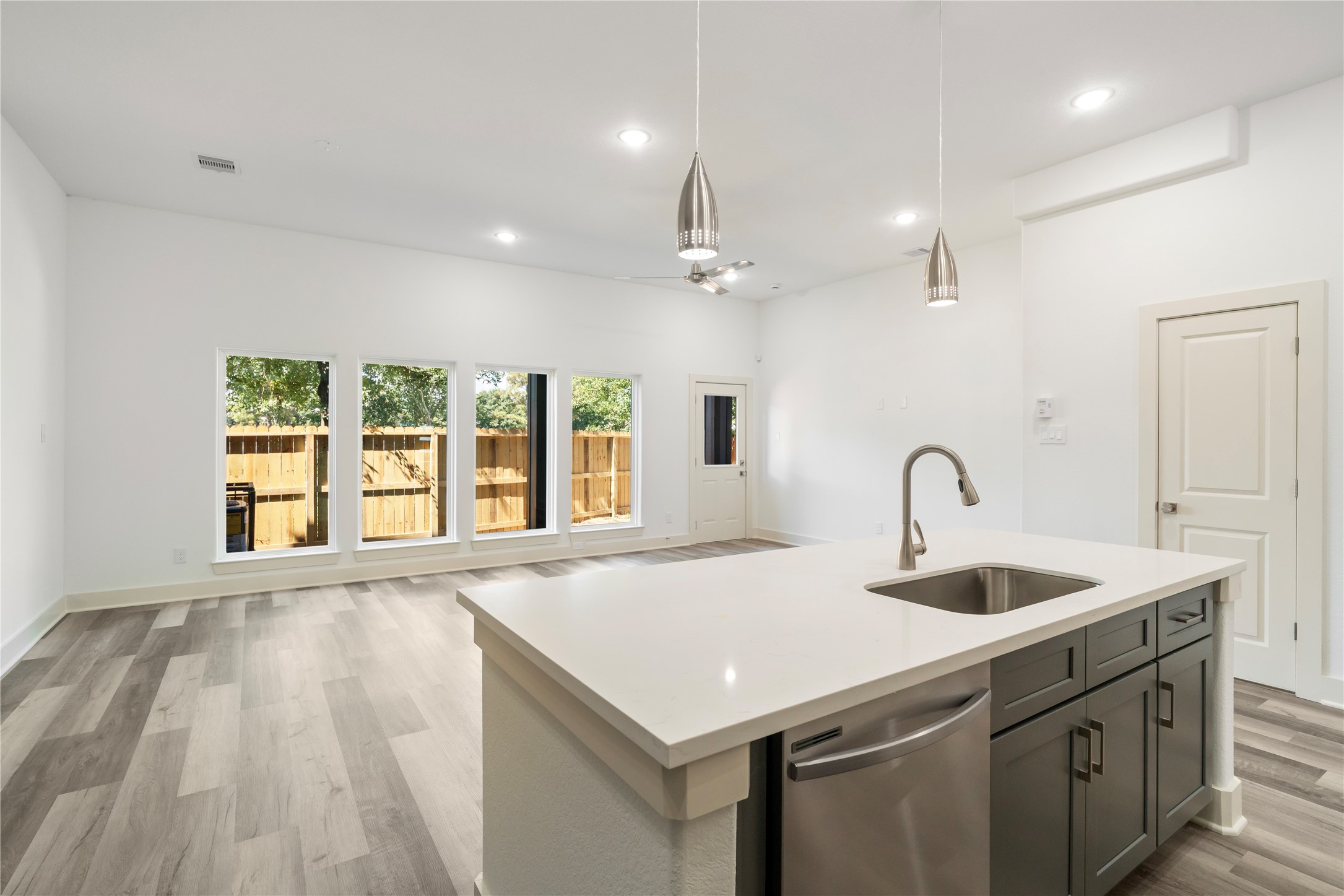 5629 Malmedy Road Houston, TX 77033 - Photo 16 of 24 Bright and spacious open-concept living area featuring modern flooring, a sleek kitchen island, and large windows offering plenty of natural light.